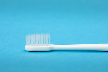 Single white toothbrush horizontal close up isolated on blue background copy space copy space