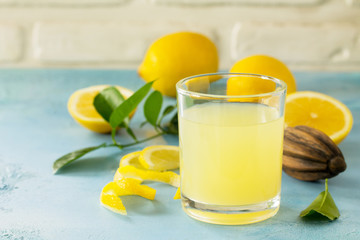 Glass of fresh freshly squeezed lemon juice on a turquoise stone or concrete table.