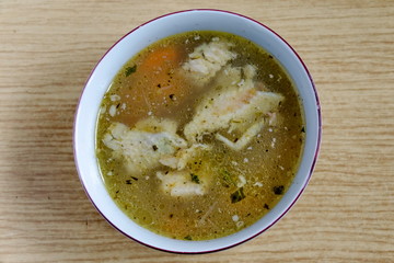Bulgarian traditional chicken soup with vegetables and spices in a white bowl, Sofia, Bulgaria  