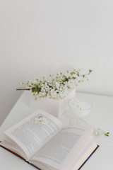 spring cherry blossoms on a white table with a book