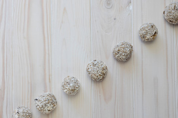 Homemade raw chocolate truffles with nuts and chia seeds in coconut flakes on a wooden background, top view, copy space, diagonal protein bars