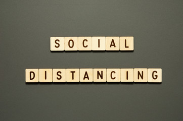 SOCIAL DISTANCING - words from wooden blocks with letters. Top view on gray background. - Image