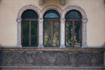 Obraz premium Italian windows on the beige wall facade with the pattern under them