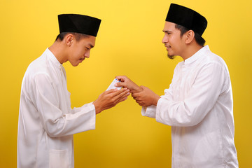 Young Asian Muslim man give alms to other muslim on Ramadan Kareem. It's the best time to give alms to everyone need