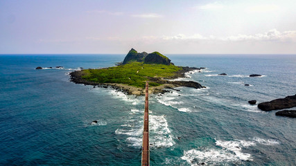 Aerial view of Sanxiantai bridge connecting the small rocky island with the shore. People walking on the bridge. Touristic destination on Taiwanese East Coast.  © Katarzyna