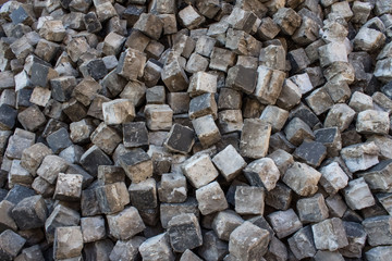 Pile of old pavement stones as creative background for your design. Granite cobblestones pavement backdrop with copyspace