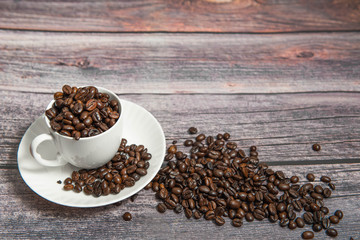 Coffee beans in a coffee cup on a wooden background