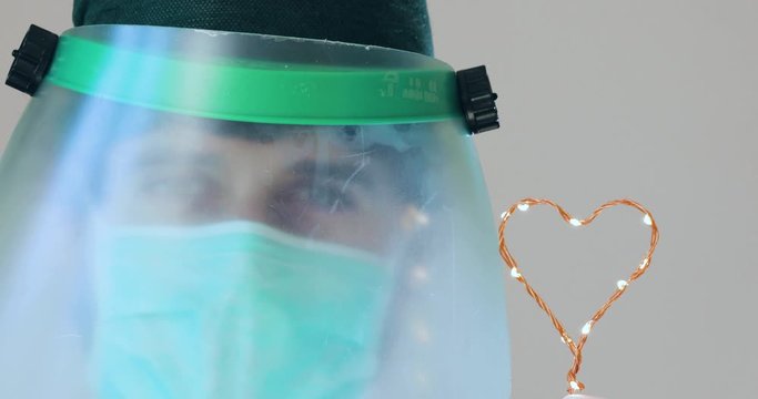 Medico responsabile della cura di coronavirus &egrave; con la visiera e un simbolo del cuore