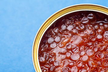 caviar in tin can on blue background