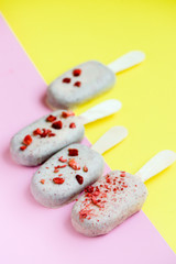 Yummy sweets. Summer food concept. Eskimo ice cream in white chocolate glaze with sublimated strawberry on pink background. Close up