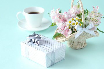 Obraz na płótnie Canvas プレゼントとコーヒーとアルストロメリアとマトアリカリアの可愛い花かご