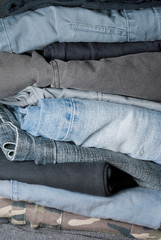 stack of folded jeans in a closet