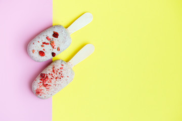 Eskimo ice cream in chocolate glaze with red sprinkles on pink background. Yummy sweet food snack treat. Top view. Copy space
