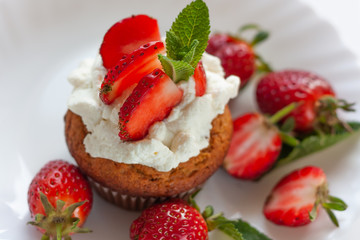 Homemade muffins with fresh strawberries on white plate. Homemade tasty dessert or breakfast. Healthy eating concept