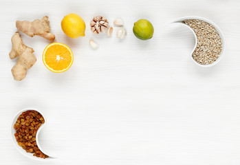 Orange, ginger, garlic, lime, lemon, raisins, sunflower seeds, organic immune products, the fight against viruses with natural remedies. Background of natural products top view. Space for text