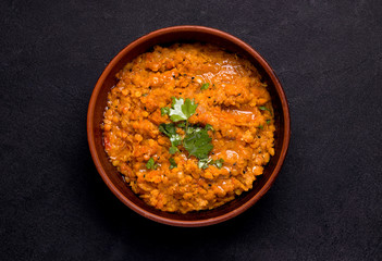 Dhal Indian soup of red lentils and spices on a black background. Traditional cuisine