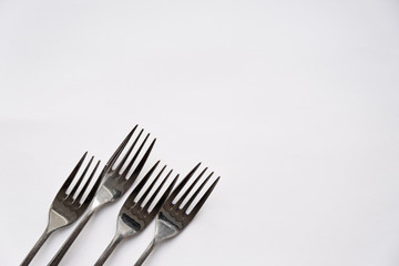 A close up of a Forks lie on a white background