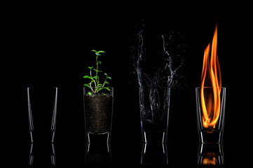 4 nature elements concept in glasses. On black backgound.