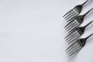Four forks lie on a white background