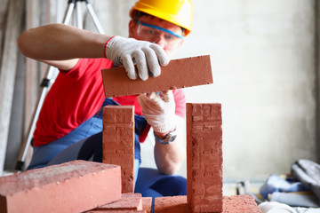 Male person constructing brickwall