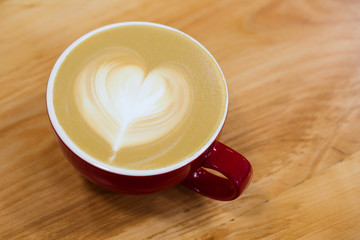 A cup of hot art cappuccino with a heart on a foam.