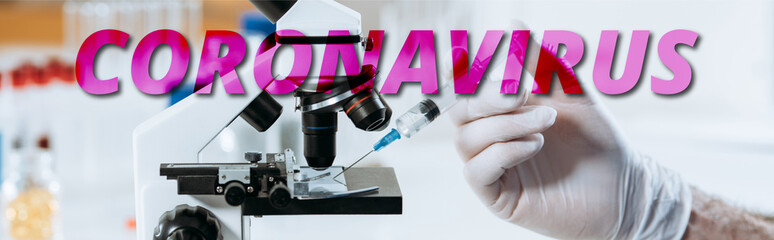 partial view of biologist in latex gloves holding syringe near microscope, panoramic shot, coronavirus illustration