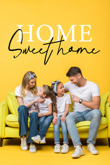happy parents talking with adorable daughter and son while sitting together on sofa on yellow, home sweet home illustration
