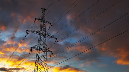 Silhouette of steel lattice tower on dramatic sky background. Transmission tower, used to support an overhead power line