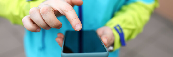 Close-up man in jacket clicks touch screen phone