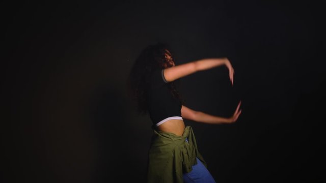 African-American woman dancing against dark background