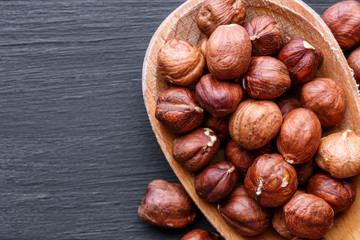 Hazelnuts in wooden bowl. Assortment of nuts - cashew, hazelnuts, walnuts, pistachio, pecans, pine nuts, peanut, raisins  on black background. Top view.