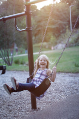 Portrait of happy little girl having fun on swing
