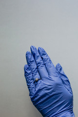 Female hand with blue latex gloves and engagement ring