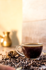 Warm cup of aromatic tasty healthy coffee against a dark background. coffee beans