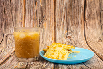 Cup of cold coffee with Crackers on a plate on wooden background.