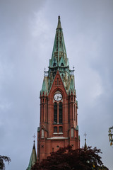 The chapel building is made of red brick with a green dome