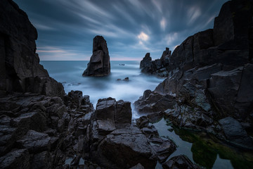 Amazing long exposure seascape with stunning rock formation in the blue hour before sunrise