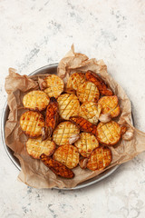 Baked potatoes and sweet potato with spices and herbs