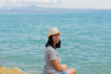 Beautiful lifestyle woman sitting and relaxing on the shore of lake contemplating amazing...