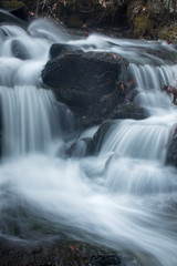 Fototapeta premium Silky, turbulent water of a small waterfall in Hebron, Connecticut.