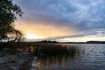 .Sky sun illumination circle phenomena above lake Wizajny. Dusk lake landscape. Wizajny, Poland, Europe.