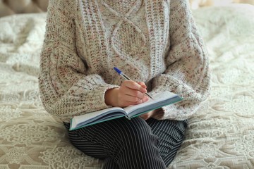 The girl works at home. Girl writes information in a notebook