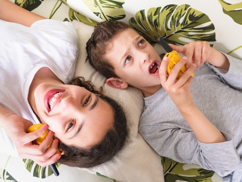 Two Children Playing With Walkie Talkie At Home