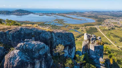 Aerial view of Pedra Branca - Garopaba. Beautiful rock formation on top of the mountain in Santa Catarina, Brazil © Jair