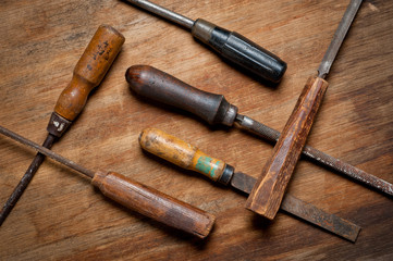 Old vintage screwdrivers and files of the last century extracted from the chest in the workshop of grandfather. Background for craftsmanship and manual labor.