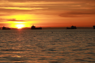 Naklejka na ściany i meble Ocean and ships during sunset