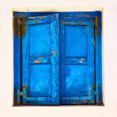 Window with closed blue shutters in Mykonos
