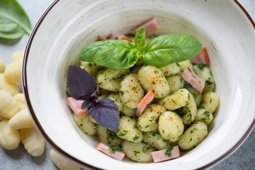 Potato gnocchi served with basil pesto sauce and chopped bacon, selective focus, closeup