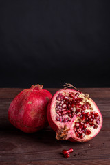 pomegranate on a wooden board on a black background