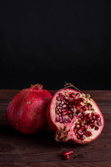 pomegranate on a wooden board on a black background